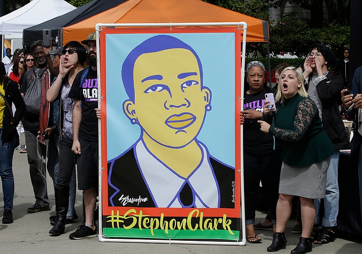 In this April 9, 2018 file photo protesters display an image of Stephon Clark at a crime victims rights rally, at the Capitol in Sacramento, Calif. Two Sacramento police officers won't face criminal charges for the fatal shooting of Clark following a chase that ended in his grandparents' yard and started a series of angry protests that roiled California's capital city, the county's top prosecutor announced Saturday, March 2, 2019, following a nearly yearlong investigation. (Rich Pedroncelli/AP, File)