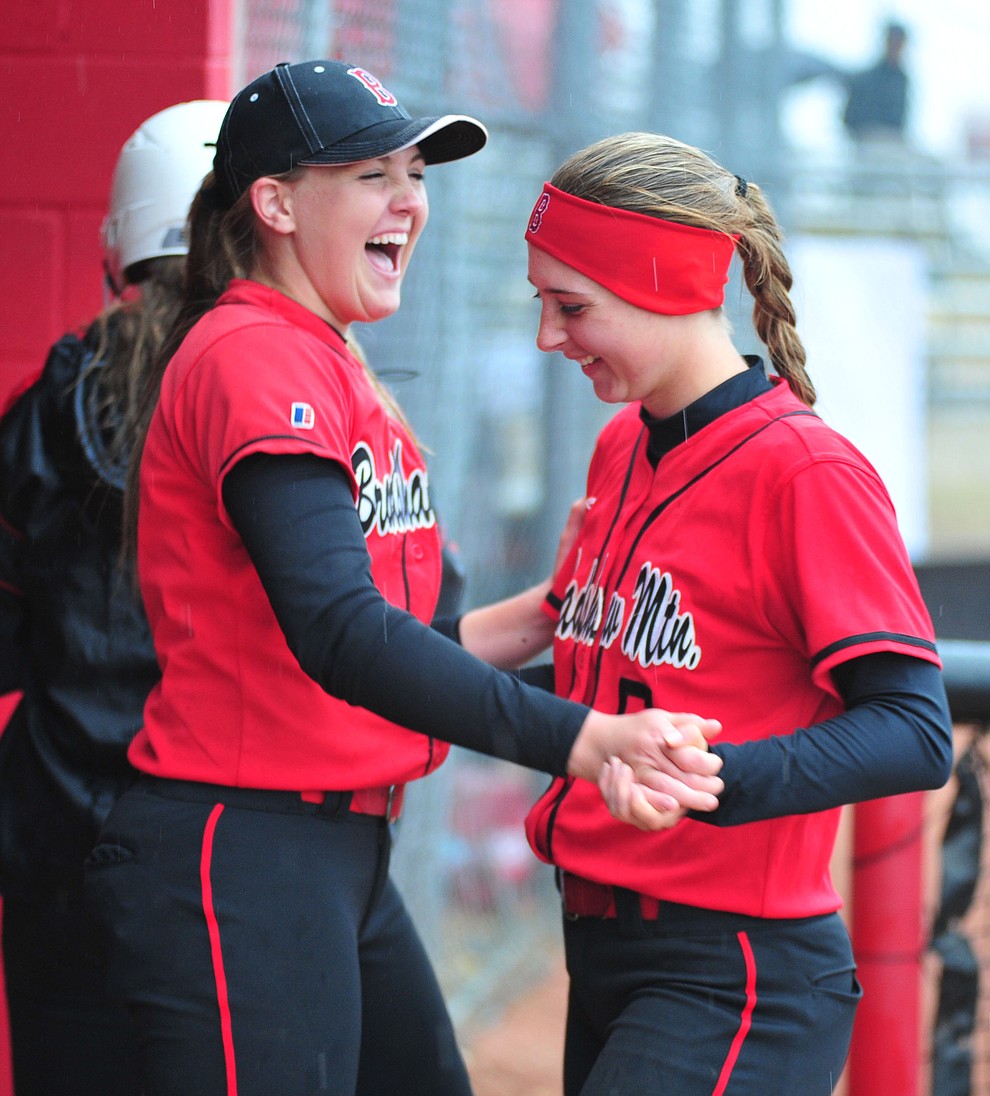 Bradshaw Mountain's Madisen Duryea and Kirsten Schmidt do a rain dance in the dugout as the Bears take on Coconino in a steady rainfall, Monday, March 11, 2019, in Prescott Valley. Les Stukenberg/Courier)