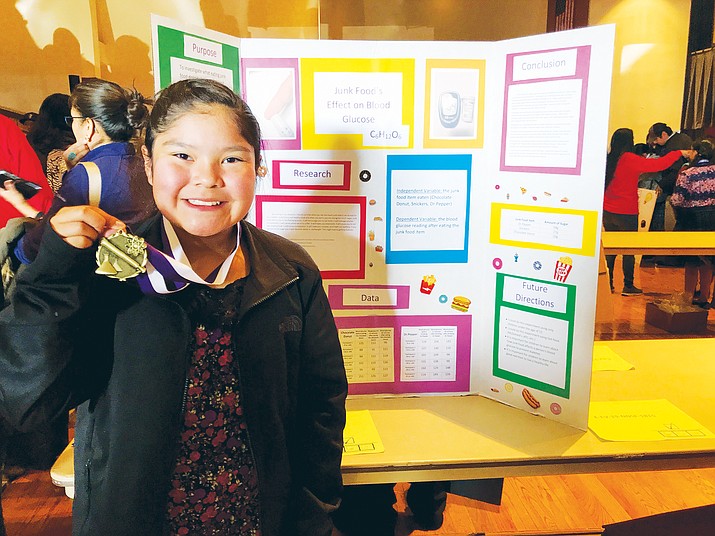 Miara Bilagody, a sixth-grade student at Tuba City Elementary School, poses with her second place medal in the biology category at the conclusion of her competition at the Navajo Nation Science Fair Feb. 27 in Church Rock, New Mexico. (Joshua L. Butler/NHO)