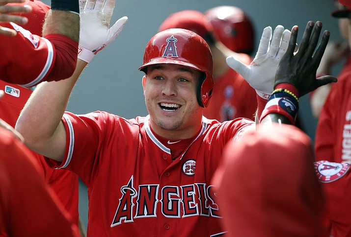 In this Sept. 10, 2017, file photo, Los Angeles Angels' Mike Trout is greeted in the dugout after hitting a solo home run in the first inning of a baseball game against the Seattle Mariners in Seattle. A person familiar with the negotiations tells The Associated Press Tuesday, March 19, 2019, that Trout and the Angels are close to finalizing a record $432 million, 12-year contract that would shatter the record for the largest deal in North American sports history. (Ted S. Warren/AP, file)