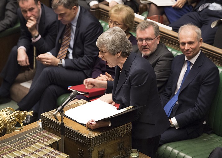 Britain's Prime Minister Theresa May stands to face opposition lawmakers inside the House of Commons parliament in London Wednesday March 27, 2019. As Lawmakers sought Wednesday for an alternative to May's unpopular Brexit deal with Europe, with a series of 'indicative votes", May offered to resign from office if her deal is passed by lawmakers at some point and Britain left the European Union. (Mark Duffy/House of Commons via AP)