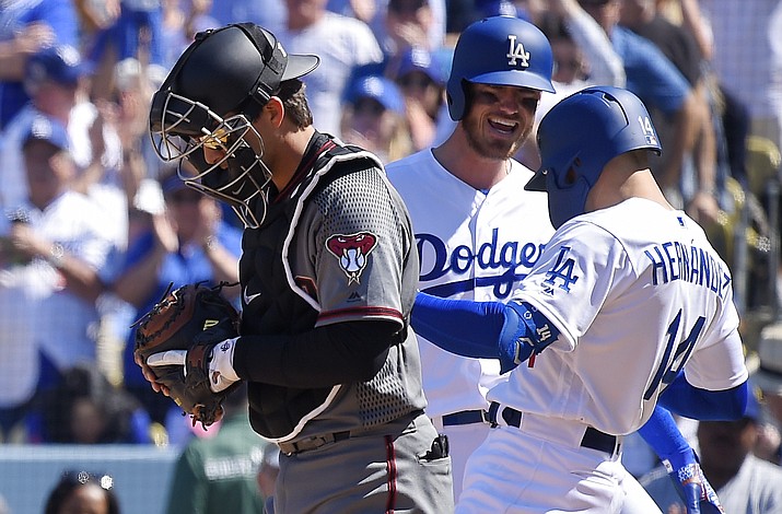 Los Angeles Dodgers' Enrique Hernandez, right, celebrates his two-run home run with Joc Pederson, center, as Arizona Diamondbacks catcher John Ryan Murphy stands at the plate during the fourth inning of a baseball game Thursday, March 28, 2019, in Los Angeles. (Mark J. Terrill/AP)