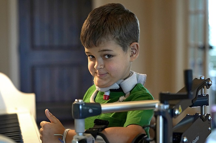 Braden Scott gives a thumbs up as he pauses while practicing on the piano in Tomball, Texas, on Friday, March 29, 2019. Braden was diagnosed with the mysterious syndrome called acute flaccid myelitis, or AFM, in 2016 and was paralyzed almost completely. But since then he has recovered much of his muscle function. His parents believe a lot of it has to do with thousands of hours of physical therapy. (David J. Phillip/AP)