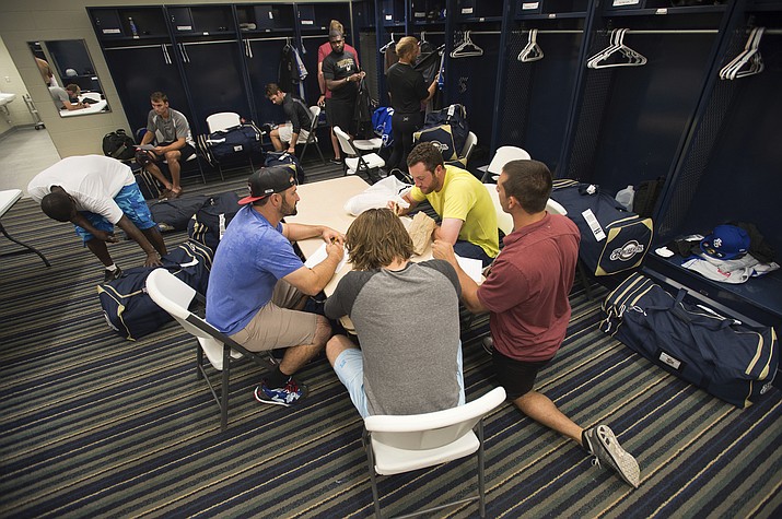 In this April 8, 2015, file photo, members of the Biloxi Shuckers minor league baseball team eat lunch before practice at the Pensacola Blue Wahoos' stadium in Pensacola, Fla. Minor leaguers at the lowest levels can make as little as $1,100 per month despite spending 50-to-70 hours per week at the ballpark. A lawsuit alleging MLB violated minimum wage and overtime requirements was pre-empted in 2018 when Congress passed the “Save America’s Pastime Act,” which stripped minor leaguers of the protection of federal minimum wage laws. (Michael Spooneybarger/AP, file)