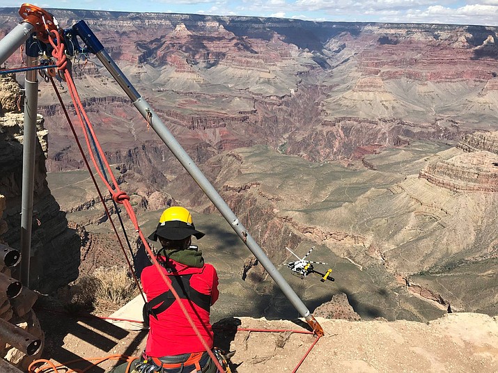 A Grand Canyon rescuer takes a break as the park helicopter moves in to long-line out the body of a 67-year-old man who fell from the edge. (GCNP/photo)