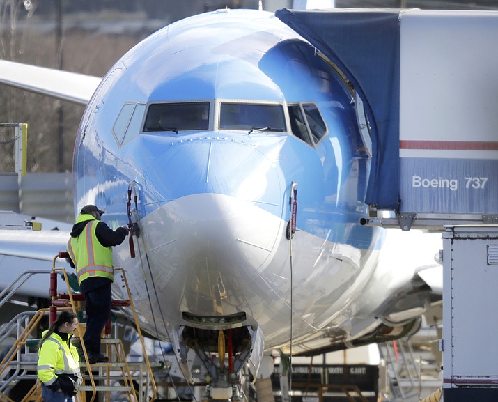 A worker stands on a platform near a Boeing 737 MAX 8 airplane being built for TUI Group on March 13, 2019, at Boeing Co.'s Renton Assembly Plant in Renton, Wash. (Ted S. Warren/AP, File)