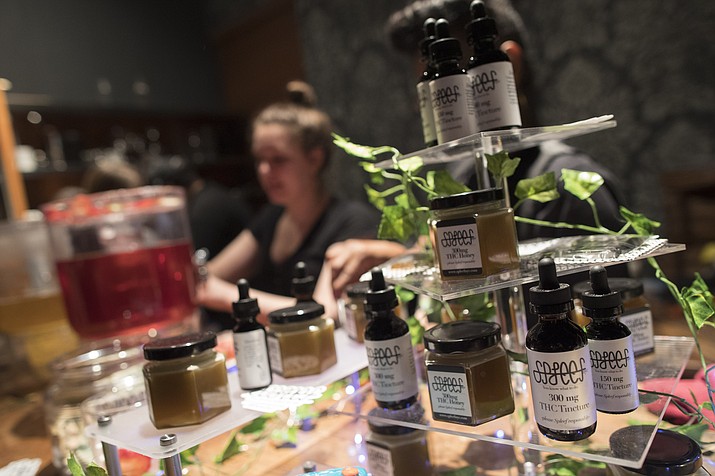 In this Friday, March 29, 2019 photo, samples of THC laced products are on display as a bartender prepares drinks at the Spleef NYC canna-cocktail party in New York. As more states make it legal to smoke marijuana, some government officials, researchers and others worry what that might mean for one of the country's biggest public health successes: curbing cigarette smoking. (Mary Altaffer/AP)