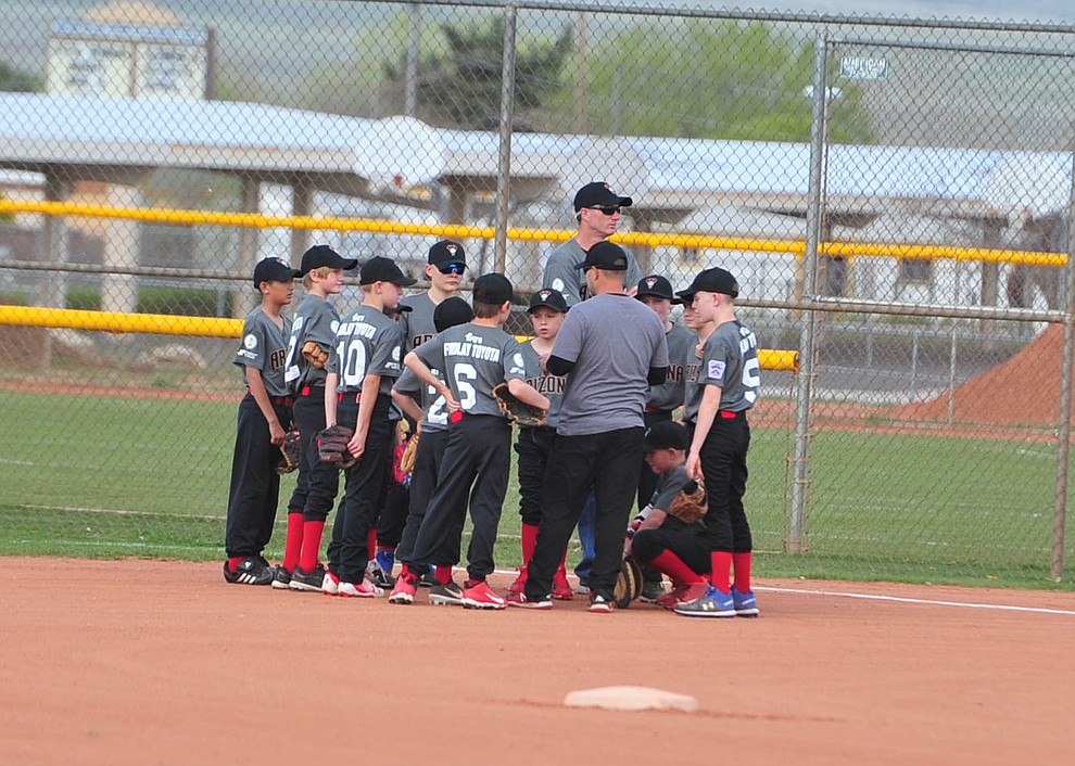 Diamondback's Findlay Toyota team gathers before the first pitch during the Prescott Valley Little League opening night Monday, April 8 at Mountain Valley Park.  (Les Stukenberg/Courier)