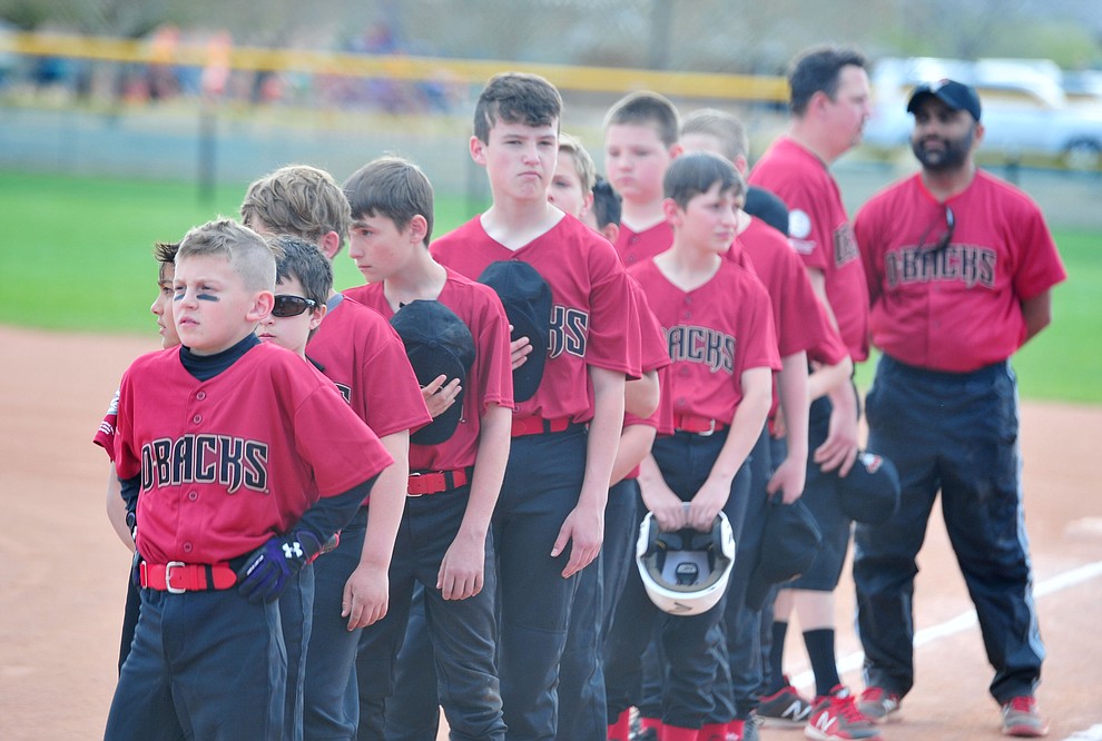 Players stand for the National Anthem during the Prescott Valley Little League opening night Monday, April 8 at Mountain Valley Park.  (Les Stukenberg/Courier)
