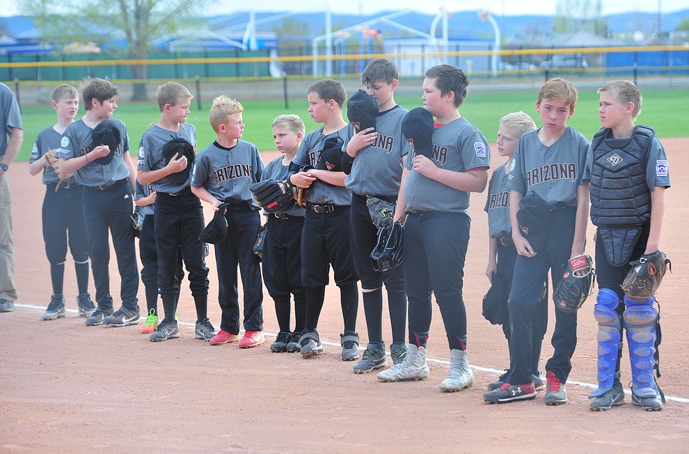 Players stand for the National Anthem during the Prescott Valley Little League opening night Monday, April 8 at Mountain Valley Park.  (Les Stukenberg/Courier)