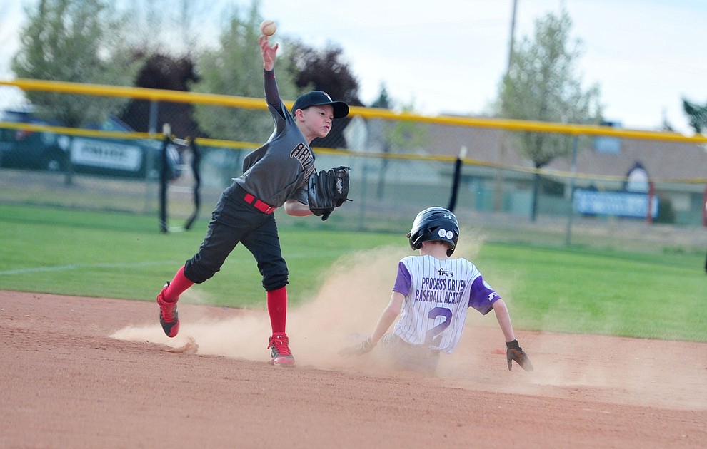 Findlay Toyota's Trevor Field tries to turn the double play on Process Driven Baseball's Matt Hepperle during the Prescott Valley Little League opening night Monday, April 8 at Mountain Valley Park.  (Les Stukenberg/Courier)