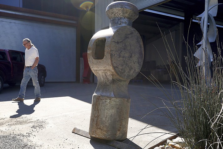 In this Friday, April 12, 2019 photo, artist Doug Unkrey, creator of the 800-pound hammer sculpture, stands beside the hammer head after its return to his studio at the Voigt Family Sculpture Foundation in Healdsburg, Calif. "The Hammer" sculpture was stolen in October 2018 from its installation at the Healdsburg Community Center. (Alvin Jornada/The Press Democrat via AP)