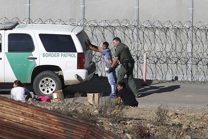 Honduran asylum seekers are taken into custody by U.S. Border Patrol agents Dec. 15, 2018, after the group crossed the U.S. border wall into San Diego, seen from Tijuana, Mexico. (Moises Castillo/AP, File)