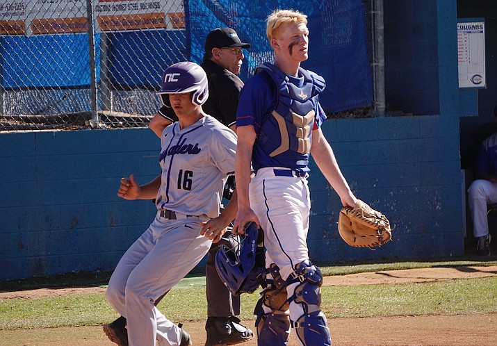 Easton Meier (16) crosses home plate for Northwest Christian as Chino Valley catcher J.R. Willingham looks out at his infield as the Cougars took on the Crusaders Thursday, April 18, 2019, in Chino Valley. (Aaron Valdez/Courier)