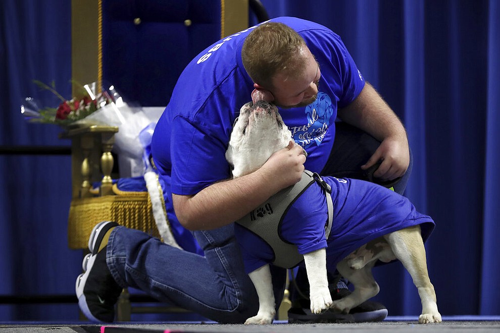 Richard Butler, of Des Moines, Iowa, gets a kiss from his dog Chubs during the 40th annual Drake Relays Beautiful Bulldog Contest, Monday, April 22, 2019, in Des Moines, Iowa. The pageant kicks off the Drake Relays festivities at Drake University where a bulldog is the mascot. (AP Photo/Charlie Neibergall)