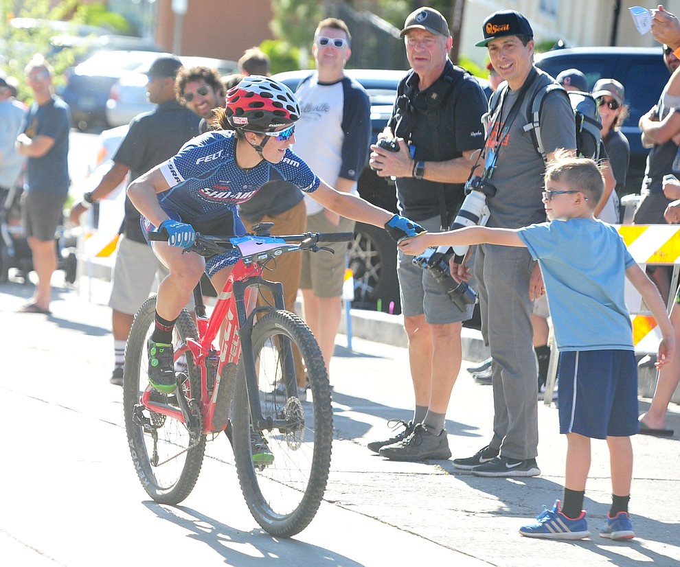 Erica Clevenger gets a hand up from a young fan during the Whiskey Off Road Fat Tire Crit through the streets of downtown Prescott Friday, April 26. (Les Stukenberg/Courier)