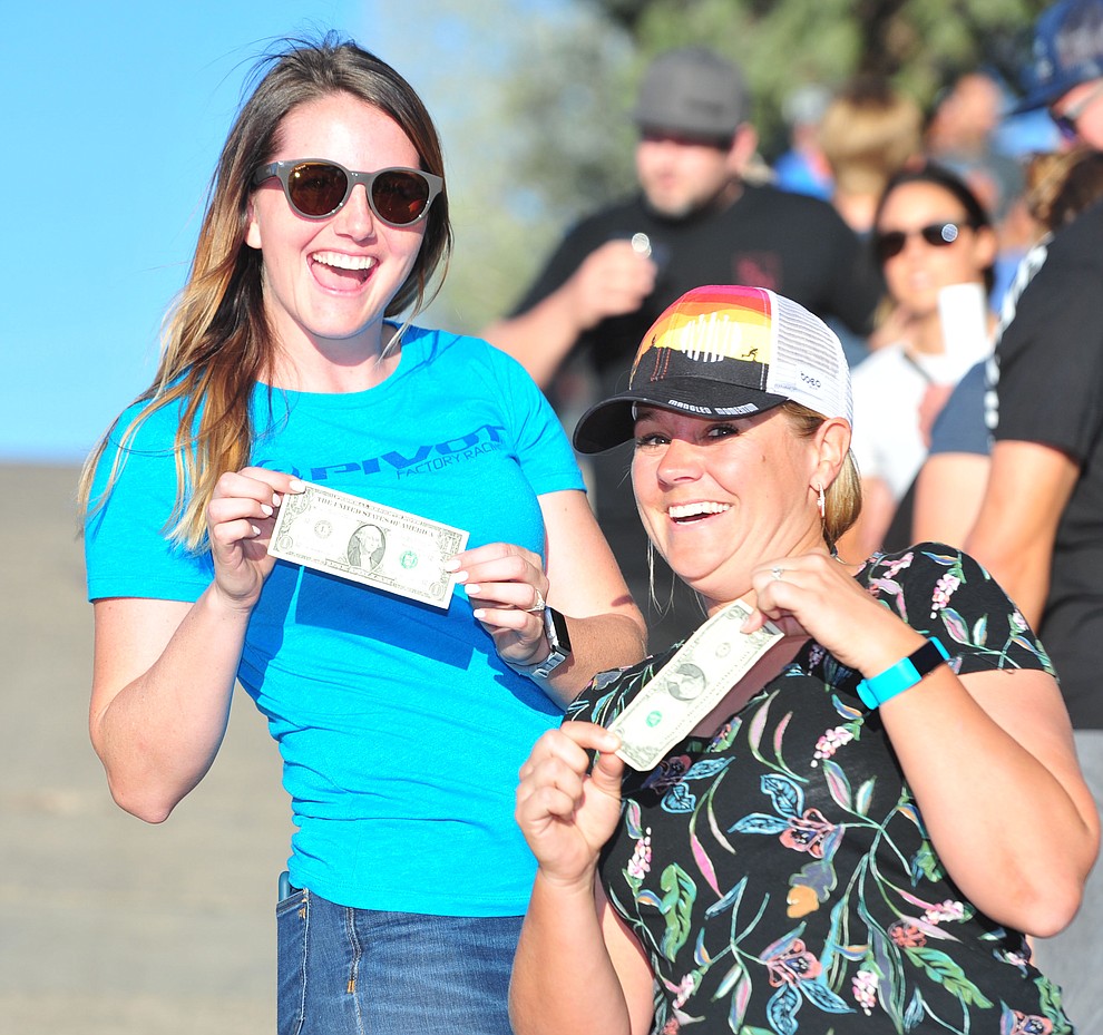 Mary Lideen and Evie Racette have their money ready for hand ups during the Whiskey Off Road Fat Tire Crit through the streets of downtown Prescott Friday, April 26. (Les Stukenberg/Courier)