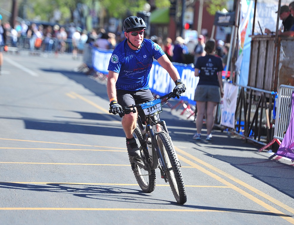 Prescott Mayor Greg Mengarelli crosses the finish line in the 15-mile race during the opening day of the Whiskey Off Road in downtown Prescott Friday, April 26. (Les Stukenberg/Courier)
