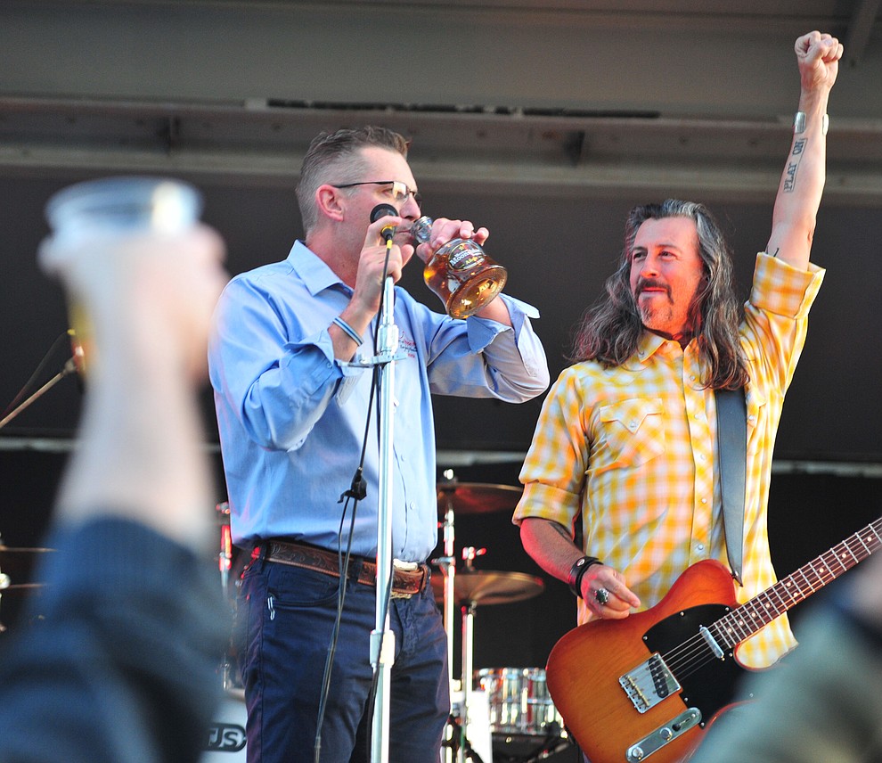 Prescott Mayor Greg Mengarelli takes a sip of Mexican Moonshine with Roger Clyne and the Peacemakers at the Whiskey Off Road in Prescott Saturday, April 27. (Les Stukenberg/Courier)