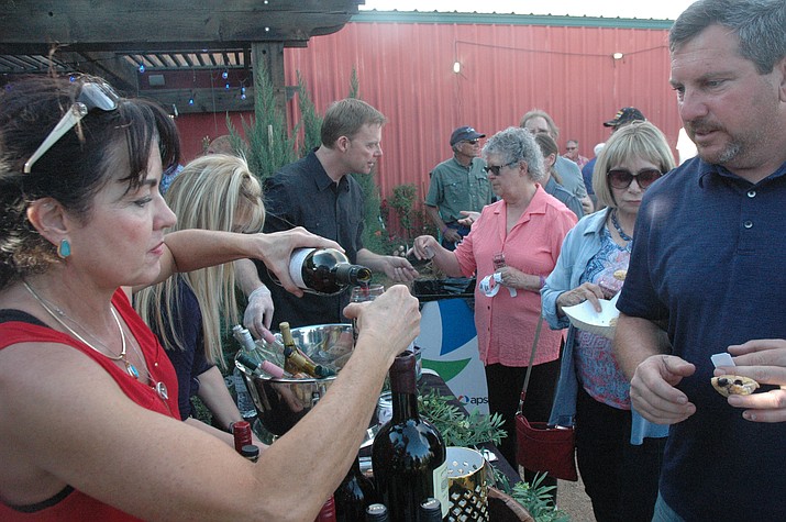Dawn Wasowicz from Rafter 11 pours some wine for Brian Ansback at the second annual Wine, Bites and Brew event, held at Earthworks Garden Supply Saturday, April 27. (Jason Wheeler/Courier)