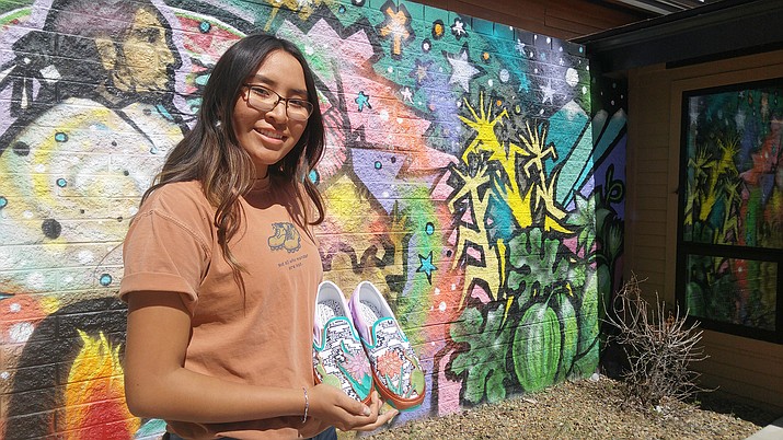 Navajo student Alyssa Williams holds her shoes in front of a mural in Flagstaff High School's courtyard April 26. She and Nicole Dougherty's shoes (below) are part of the Vans Custom Culture competition in which students from across the country design Vans shoes.  (Kevin Moriarty/NHO)