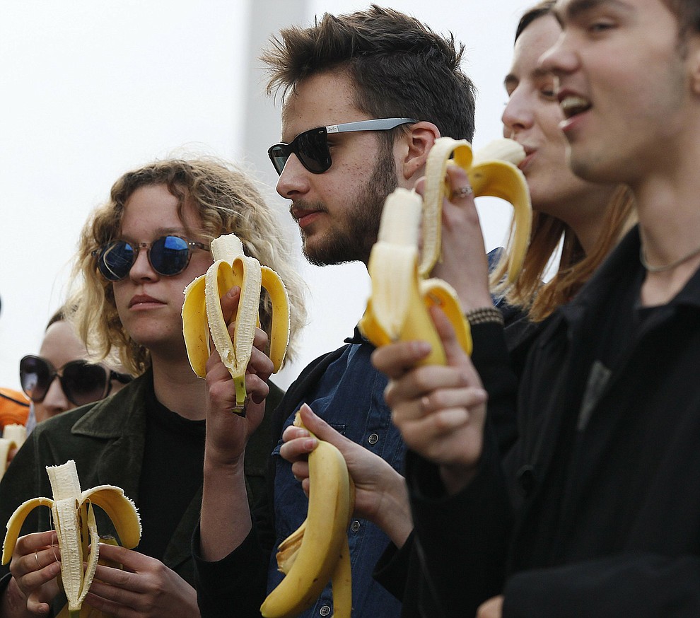 People with bananas demonstrate with others outside Warsaw's National Museum, Poland, Monday, April 29, 2019, to protest against what they call censorship, after authorities removed an artwork at the museum featuring the fruit, saying it was improper. (AP Photo/Czarek Sokolowski)
