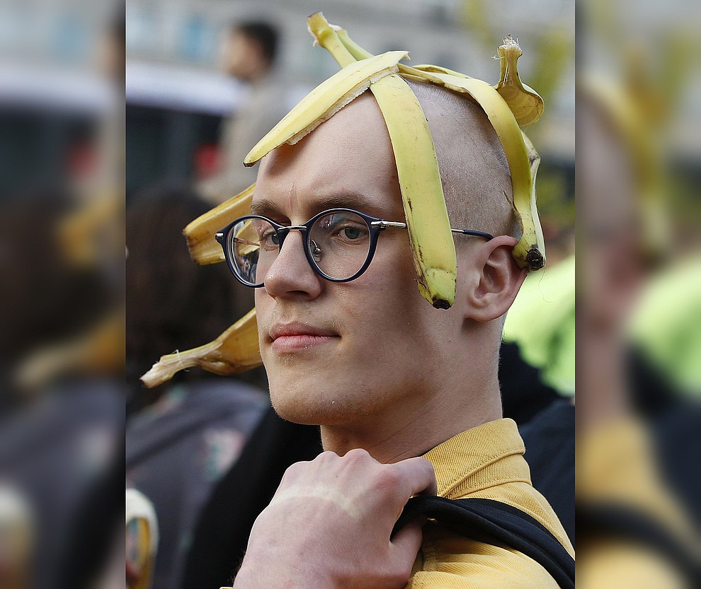 A man with bananas demonstrates with others outside Warsaw's National Museum, Poland, Monday, April 29, 2019, to protest against what they call censorship, after authorities removed an artwork at the museum featuring the fruit, saying it was improper. (AP Photo/Czarek Sokolowski)