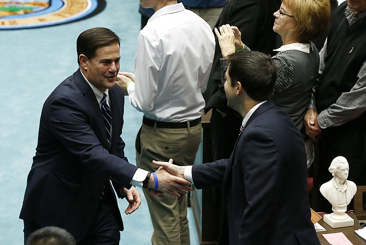 Arizona Republican Gov. Doug Ducey, left, shakes hands with Paul Boyer, R-Phoenix on Jan. 8, 2018, in Phoenix. Boyer is threatening to hold up the state budget until he gets a vote on his plan to give victims of childhood sexual abuse more time to sue their attackers. (Ross D. Franklin/AP, file)