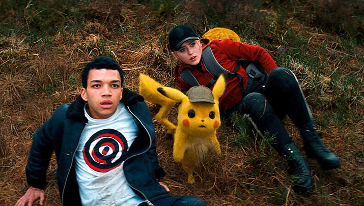 This image released by Warner Bros. Pictures shows Justice Smith, left, the character Detective Pikachu, voiced by Ryan Reynolds, and Kathryn Newton in a scene from "Pokemon Detective Pikachu." (Warner Bros. Pictures via AP)