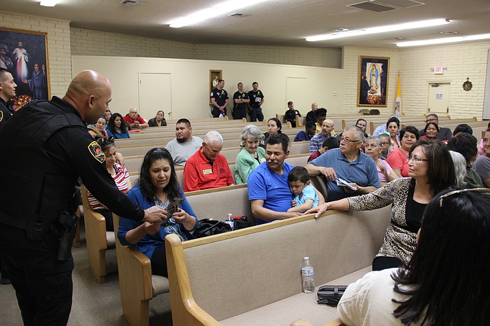 Prescott Valley Police Department officer Gabe Maldonado hands out information pamphlets to attendees of the department’s Latino Town Hall on Friday, May 3, at St. Germaine Catholic Church in Prescott Valley. (Max Efrein/Courier)