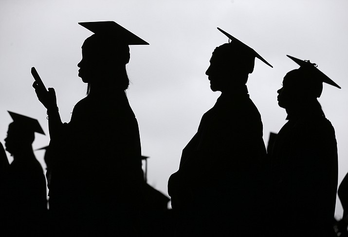 In this May 17, 2018, file photo, new graduates line up before the start of the Bergen Community College commencement at MetLife Stadium in East Rutherford, N.J. A college degree has long been a ticket to the U.S. middle class. Yet a new survey shows that college graduates aren t as likely as they once were to feel they belong to the middle class. (Seth Wenig/AP)