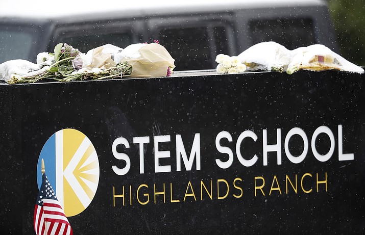 A light snow covers bouquets of flowers placed on the sign for STEM School Highlands Ranch following Tuesday's shooting, in Highlands Ranch, Colo., Thursday, May 9, 2019. (David Zalubowski/AP)
