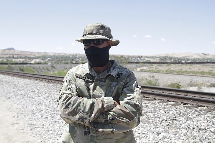 In this April 23, 2019, file photo, a self-styled Patriot stands a quarter mile from a barrier that marks the U.S.-Mexico border after his group, United Constitutional Patriots, gained national attention for filming themselves detaining immigrants near Sunland Park, N.M. Throughout U.S. history, private, armed groups have been hired or appointed themselves to police the U.S-Mexico border for a variety of reason, ranging from preventing Chinese immigrants from crossing over illegally to preventing runaway slaves from fleeing. (Cedar Attanasio/AP, File)