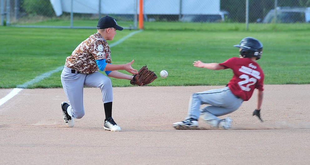 Pace Norman tries to field a hit as Karson Frost slides into third as the Grand Highland Cobras faced off against the Process Driven Baseball Diamondbacks in the Prescott Little League Minors City Championship Game Friday, May 17.  (Les Stukenberg/Courier)