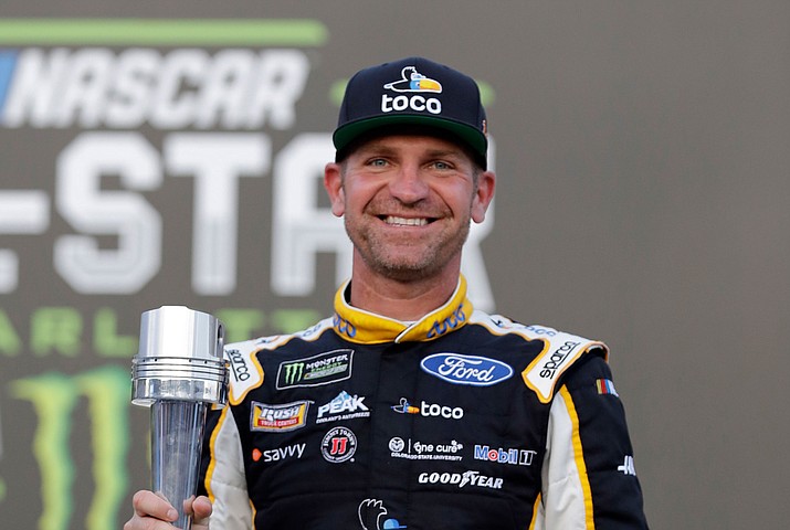 Clint Bowyer poses with the award in Victory Lane after winning the pole position for Saturday's NASCAR All-Star auto race during qualifying at Charlotte Motor Speedway in Concord, N.C., Friday, May 17, 2019. (Chuck Burton/AP)