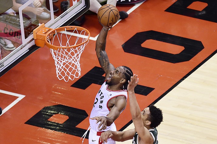 Toronto Raptors forward Kawhi Leonard (2) scores past Milwaukee Bucks guard Malcolm Brogdon (13) during the second overtime period of Game 3 of the NBA playoffs Eastern Conference finals in Toronto on Sunday, May 19, 2019. (Frank Gunn/The Canadian Press via AP)