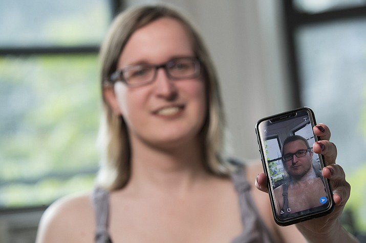 In this Wednesday, May 15, 2019, photo, Bailey Coffman shows her photo as a man in the Snapchat app during an interview in New York. Snapchat's new photo filter that allows users to change into a man or woman with the tap of a finger isn’t necessarily fun and games for transgender people. But some others see the potential for such tools to lead to self-discovery among people struggling with their gender identity. (AP Photo/Mary Altaffer)