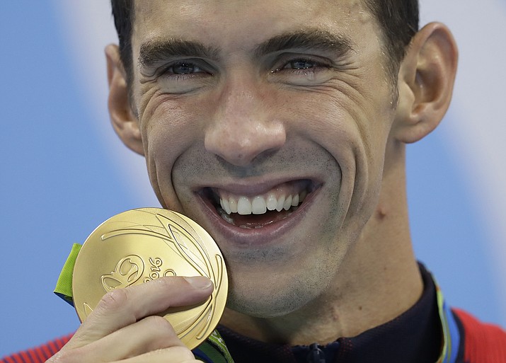 In this Aug. 9, 2016, file photo, Michael Phelps has tears in his eyes as he shows off his gold medal after the men's 200-meter butterfly final during the swimming competitions at the 2016 Summer Olympics, in Rio de Janeiro, Brazil. While swimming to Olympic glory, Phelps found comfort in the pool and quite a bit of angst out of it. Because he is willing to share his story of depression and raise awareness of mental health issues, Phelps will be awarded the fifth annual Morton E. Ruderman Award in Inclusion on Tuesday night, May 21, 2019, in Boston. (AP Photo/Michael Sohn, File)