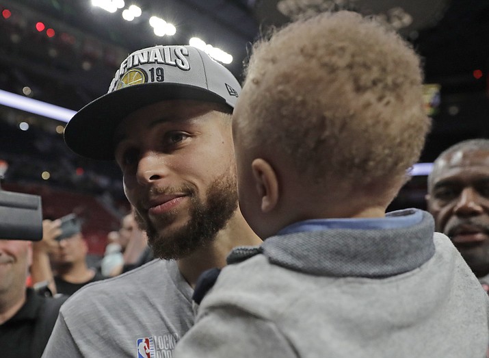 Golden State Warriors guard Stephen Curry holds his son Canon as he walks off the court after Game 4 of the NBA basketball playoffs Western Conference finals against the Portland Trail Blazers, Monday, May 20, 2019, in Portland, Ore. The Warriors won 119-117 in overtime. (Ted S. Warren/AP)