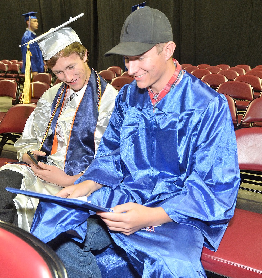 Nicholas Swartwout and Brandon Farnsworth check out the top of his mortar board before Chino Valley HIgh School graduated 153 students in a commencement ceremony Wednesday, May 22 at the Findlay Toyota Center in Prescott Valley. (Les Stukenberg/Courier)