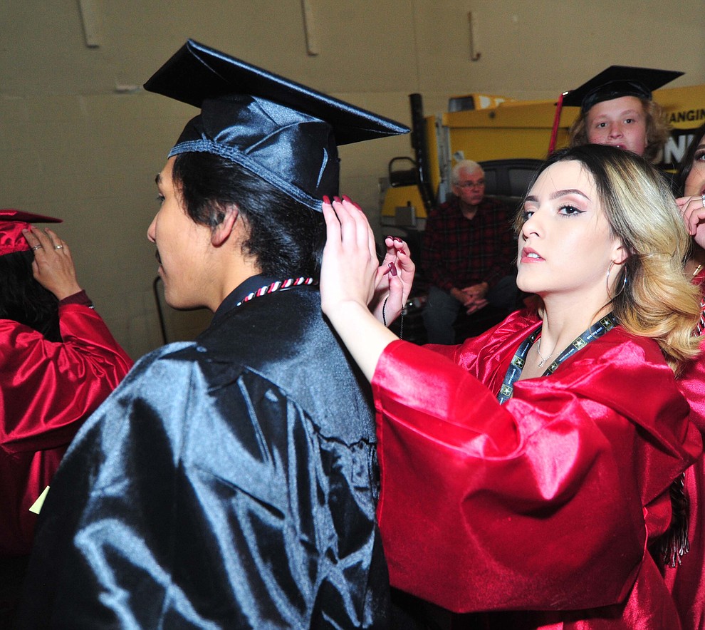 Karina Ayala Flores helps Jose Gutierrez before Bradshaw Mountain High School graduated 334 students in a commencement ceremony Thursday, May 23 at the Findlay Toyota Center in Prescott Valley. (Les Stukenberg/Courier)