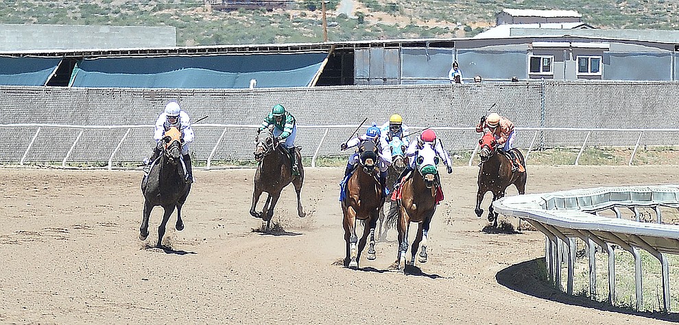 Horses round the far turn in the first race at opening day of Arizona Downs Friday, May 24 in Prescott Valley. The racetrack reopens under new ownership after being closed for 10 years. (Les Stukenberg/Courier)