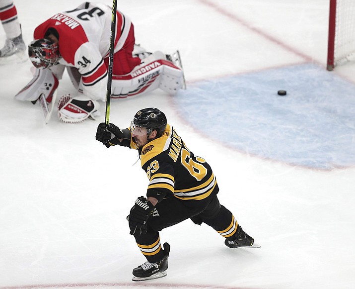 Boston’s Brad Marchand raises his stick as Carolina goaltender Petr Mrazek drops to the ice after a goal by Patrice Bergeron during Game 1 of the NHL Eastern Conference finals Thursday, May 9, 2019, in Boston. (Charles Krupa/AP)
