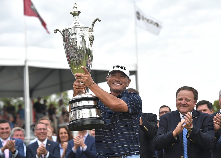 Ken Tanigawa raises the Alfred S. Bourne Trophy after the Senior PGA Championship golf tournament, Sunday, May 26, 2019, in Rochester, N.Y. Tanigawa won the championship. (Adrian Kraus/AP)