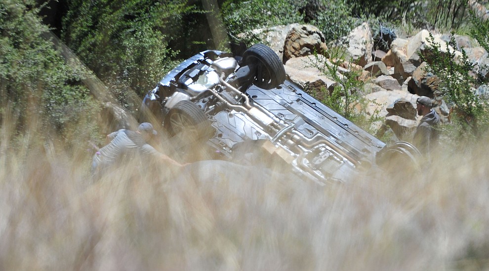 Arizona Department of Public Safety (DPS) investigators are on the scene where a stolen vehicle was run off a cliff at mile marker 303 on Highway 89 Monday, May 28 between Prescott and Wilhoit. The vehicle is approximately 500 feet down a steep hillside, landing in a drainage. (Les Stukenberg/Courier)