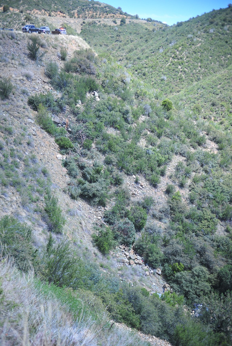 Arizona Department of Public Safety (DPS) investigators are on the scene where a stolen vehicle was run off a cliff at mile marker 303 on Highway 89 Monday, May 28 between Prescott and Wilhoit. The vehicle is approximately 500 feet down a steep hillside, landing in a drainage. (Les Stukenberg/Courier)