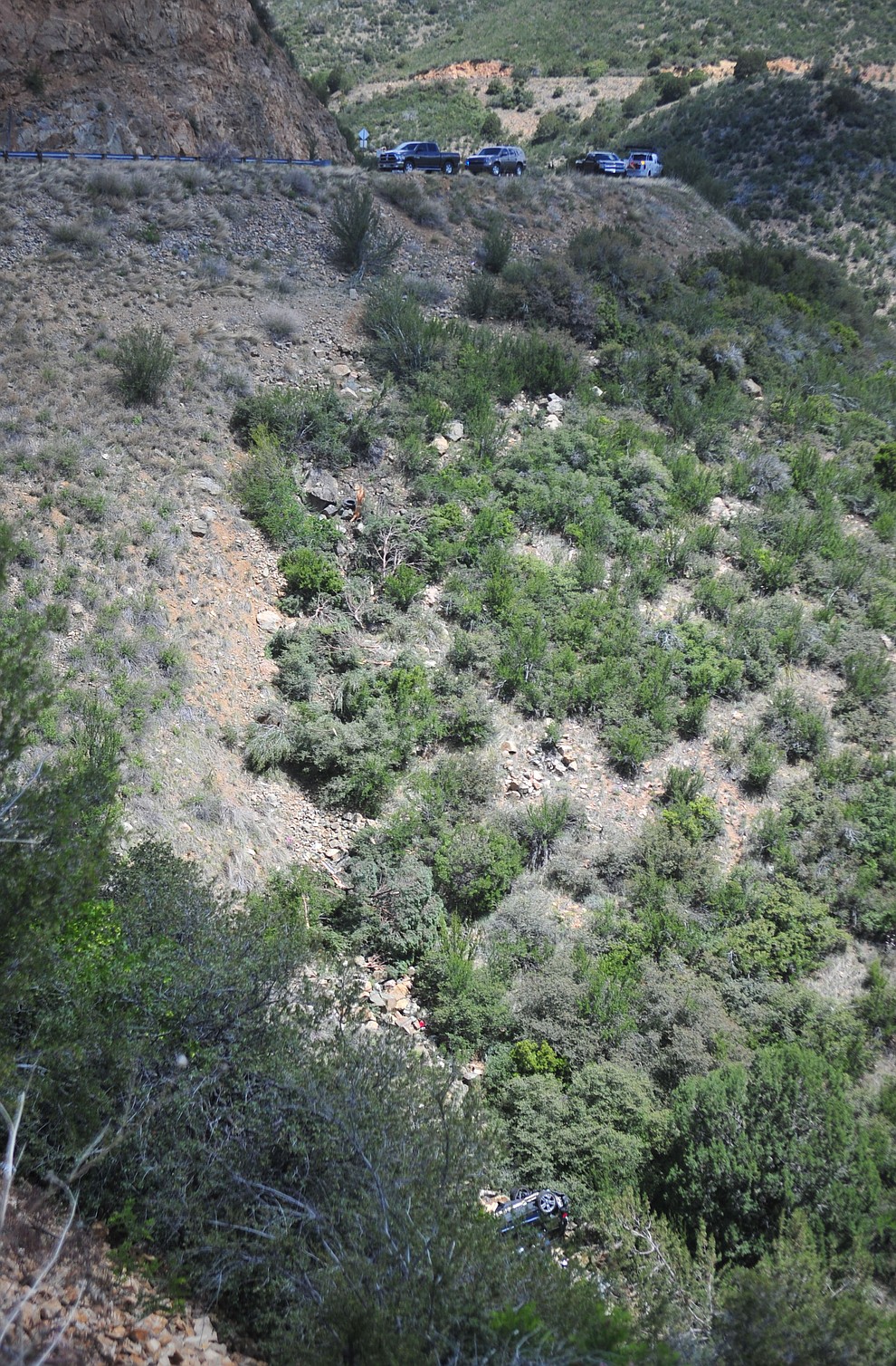 Arizona Department of Public Safety (DPS) investigators are on the scene where a stolen vehicle was run off a cliff at mile marker 303 on Highway 89 Monday, May 28 between Prescott and Wilhoit. The vehicle is approximately 500 feet down a steep hillside, landing in a drainage. (Les Stukenberg/Courier)