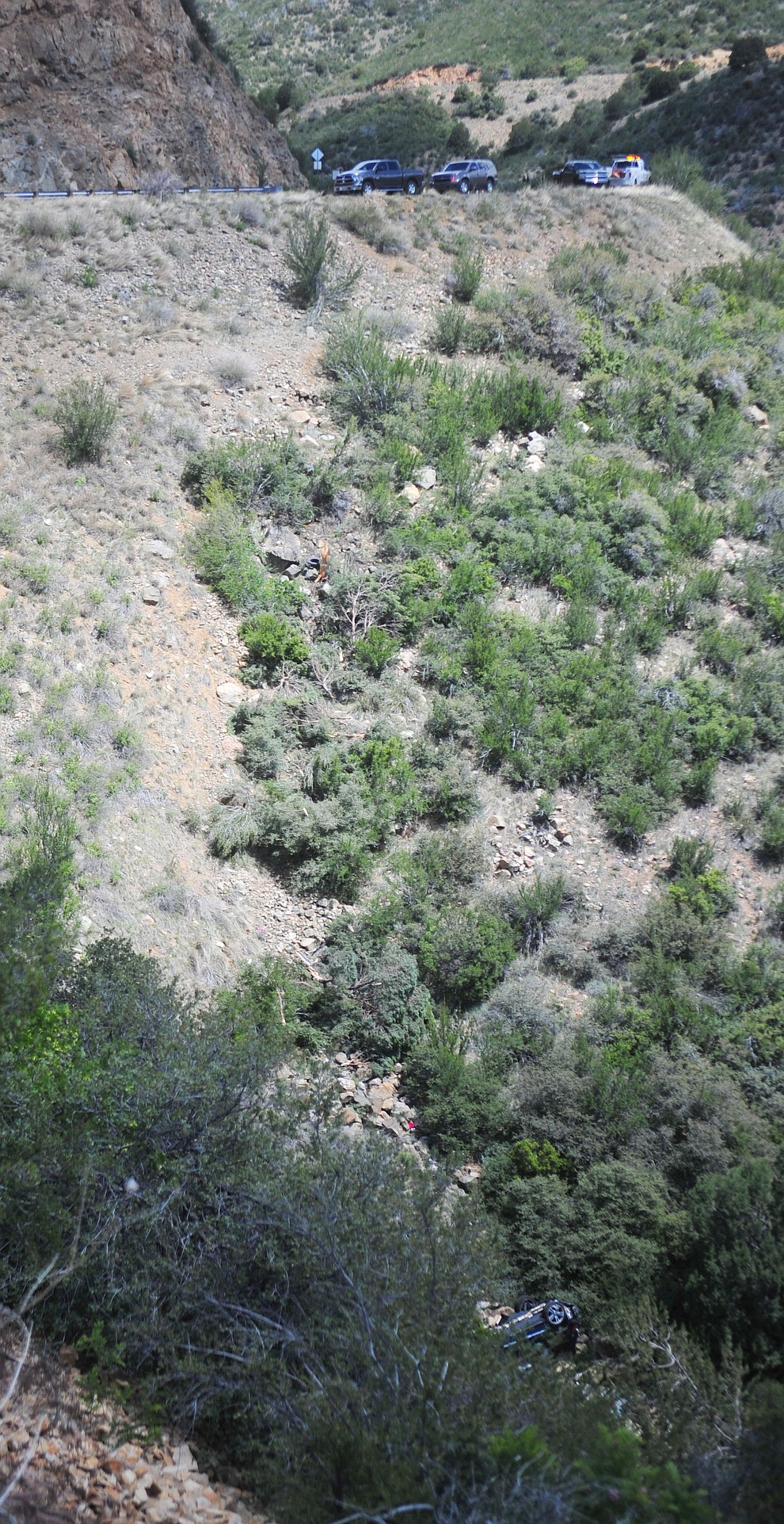 Arizona Department of Public Safety (DPS) investigators are on the scene where a stolen vehicle was run off a cliff at mile marker 303 on Highway 89 Monday, May 28 between Prescott and Wilhoit. The vehicle is approximately 500 feet down a steep hillside, landing in a drainage. (Les Stukenberg/Courier)