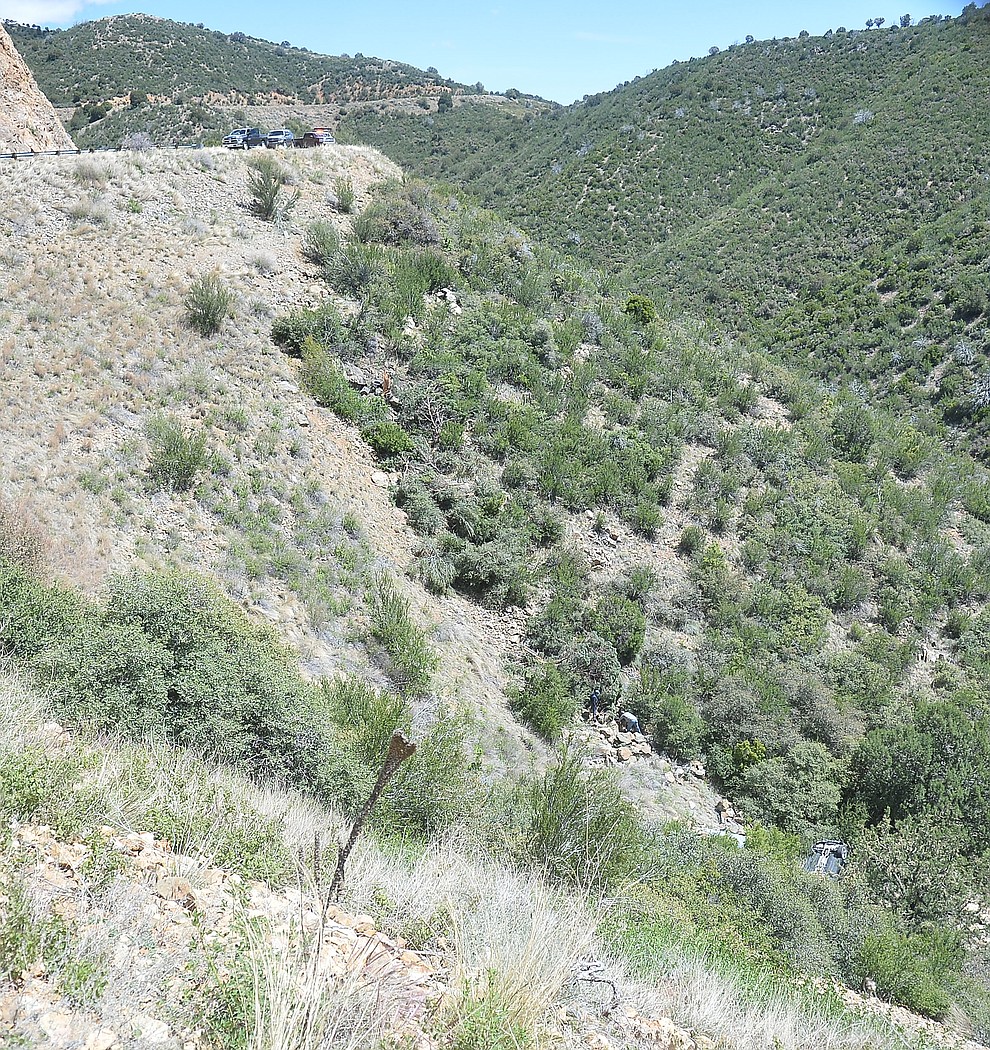 Arizona Department of Public Safety (DPS) investigators are on the scene where a stolen vehicle was run off a cliff at mile marker 303 on Highway 89 Monday, May 28 between Prescott and Wilhoit. The vehicle is approximately 500 feet down a steep hillside, landing in a drainage. (Les Stukenberg/Courier)