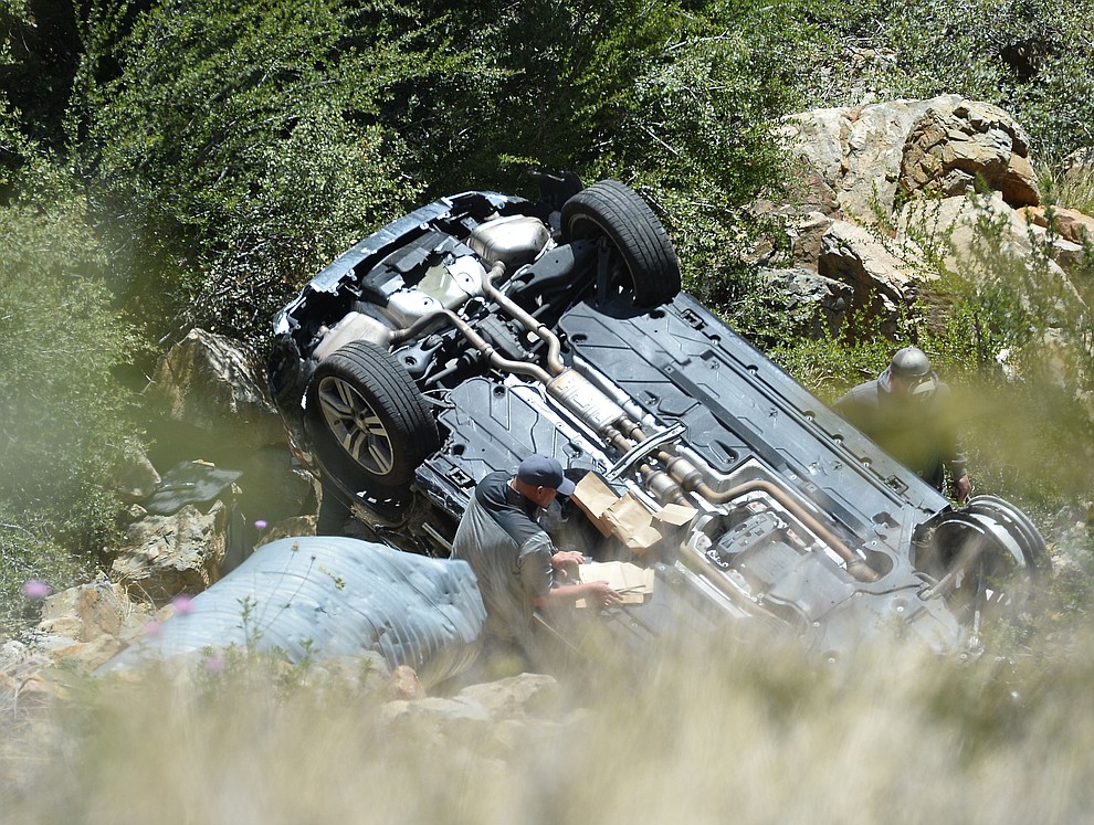 Arizona Department of Public Safety (DPS) investigators are on the scene where a stolen vehicle was run off a cliff at mile marker 303 on Highway 89 Monday, May 28 between Prescott and Wilhoit. The vehicle is approximately 500 feet down a steep hillside, landing in a drainage. (Les Stukenberg/Courier)